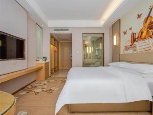 南昌维也纳国际酒店南昌青山湖万达广场店的卧室配有一张白色大床和一台平面电视。