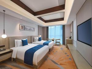 徐州郁锦香酒店(徐州汉文化景区世茂广场店)的酒店客房设有两张床和一台平面电视。