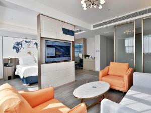 南昌凯里亚德酒店(南昌象湖金沙大道店)的带沙发、电视和床的客厅