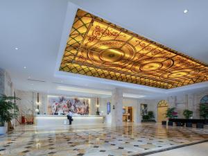 重庆维也纳国际酒店重庆北站店的大型大堂设有大天花板和绘画作品