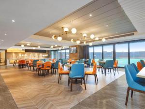 晋江凯里亚德酒店(泉州晋江国际机场店)的用餐室设有桌椅和窗户。