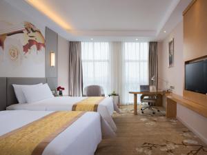 武义维也纳国际酒店·浙江武义壶山店的酒店客房设有两张床和一台平面电视。