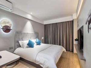 Jiangning白玉兰南京航空航天大学胜太西路酒店的卧室配有带蓝色枕头的大型白色床
