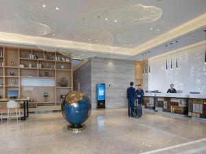 汉中凯里亚德酒店(汉中高铁站店)的两个人站在图书馆里,拿着一个大蓝球