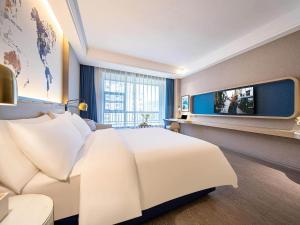 都匀凯里亚德酒店(都匀万达广场店)的酒店客房设有一张大床和一台电视机。