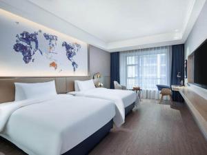 都匀凯里亚德酒店(都匀万达广场店)的酒店客房设有两张床和一张世界地图
