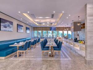 南汇凯里亚德酒店(上海国际旅游度假区浦东机场店)的一间设有蓝色桌椅的餐厅和一间酒吧