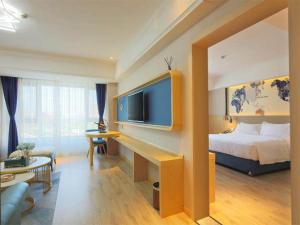 哈尔滨凯里亚德酒店(哈尔滨西站万达广场店)的配有一张床和一台平面电视的酒店客房