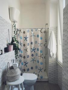 丽都迪奥斯蒂亚Lungomare Toscanelli 206 room fronte mare的浴室配有带卫生间的淋浴帘