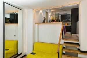 陶尔米纳Giasone Apartments的客厅里一张黄色的沙发,配有镜子