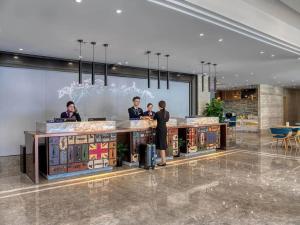 南汇凯里亚德酒店(上海国际旅游度假区浦东机场店)的一群人站在大堂的柜台上