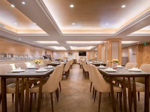 运城维也纳酒店山西运城槐东路店的大型用餐室配有桌椅