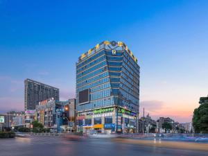 镇江7天酒店·丹阳火车站吾悦广场店的一座高大的建筑,上面有灯