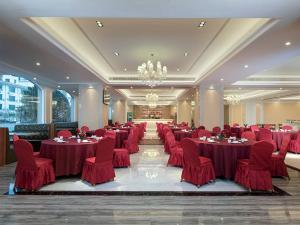 Longnan维也纳国际酒店赣州龙南迎宾大道店的一个带红色桌椅的大型宴会厅