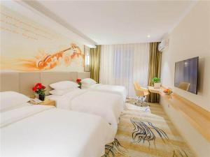 牡丹江维也纳智好酒店牡丹江火车站步行街店的酒店客房设有三张床和电视。