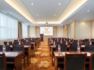 无锡维也纳国际酒店江苏无锡太湖博览中心店的配有桌椅和讲台的会议室