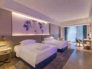 莲塘凯里亚德酒店(深圳麟恒广场六约地铁站店)的酒店客房配有两张床和一张书桌