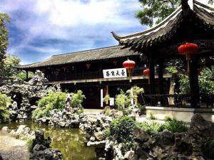 扬州锦江之星品尚(扬州瘦西湖四望亭路店)的一座在寺庙前有池塘的建筑