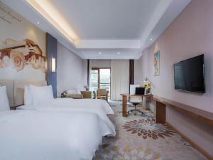 Longnan维也纳国际酒店赣州龙南迎宾大道店的酒店客房设有两张床和一台平面电视。
