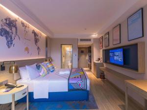 莲塘凯里亚德酒店(深圳麟恒广场六约地铁站店)的配有一张床和一台平面电视的酒店客房
