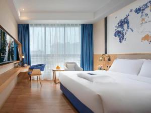 汉中凯里亚德酒店(汉中高铁站店)的酒店客房设有一张白色大床和一个窗户。