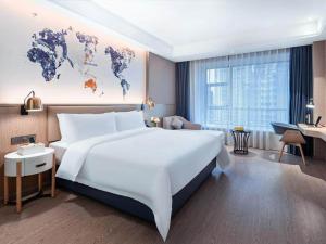 都匀凯里亚德酒店(都匀万达广场店)的一张大白床,位于酒店客房内,拥有世界地图