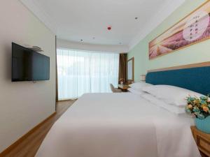 Matunlijia维也纳3好酒店江苏丹阳后巷店的卧室配有一张白色大床和一台平面电视。