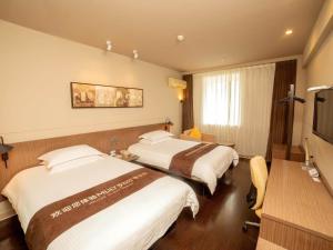 扬州锦江之星品尚(扬州瘦西湖四望亭路店)的酒店客房设有两张床和电视。