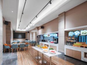 宝安凯里亚德酒店(深圳光明圳美地铁站店)的客房设有厨房和带水果的桌子。