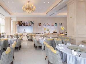宝安维也纳国际酒店深圳国际会展中心南门店的一间带桌椅和吊灯的用餐室