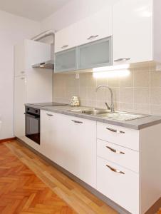 尼亚卢卡Apartman Žuvela的厨房配有白色橱柜和水槽
