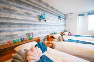 宫古岛Hotel Santa Barbara Miyakojima Resort的一间卧室设有三张床和木墙