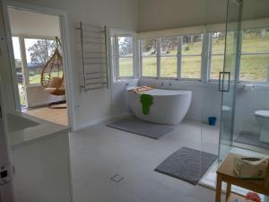 DalveenGalah Cottage Stanthorpe的带浴缸和玻璃淋浴间的浴室。