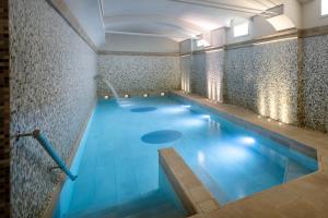 米兰UNAHOTELS Galles Milano的大楼内的一个蓝色海水游泳池