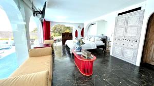 乌鲁瓦图莫拉比托艺术克里夫别墅的一间卧室配有一张床、一张沙发和一张桌子