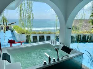 乌鲁瓦图莫拉比托艺术克里夫别墅的带浴缸的浴室,享有海景