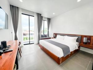 贡布Emerald Residence Kampot的卧室配有一张床、一张书桌和窗户。