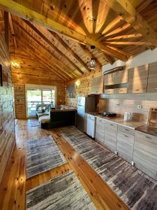乌尔齐尼Cottage Ajna - Ada Bojana的一个带木制天花板的大厨房和一个客厅
