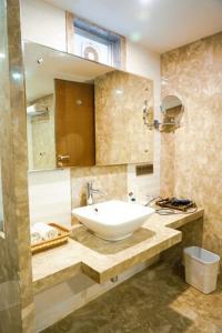 印多尔华威酒店的浴室设有白色水槽和镜子