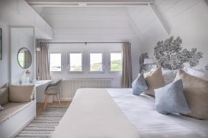 坡隆维茨普尔扎伊帕拉格酒店的白色卧室配有一张大床和一张书桌
