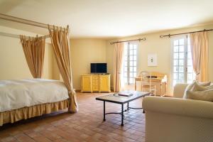 洛尔格Château les Crostes的一间卧室配有一张床、一张沙发和一张桌子