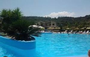坎波菲利斯·迪·罗切Casa vacanza DF con piscina的一座蓝色海水和椅子的大型游泳池