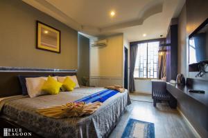 清莱Blue Lagoon Hotel的一间卧室配有黄色和蓝色枕头的床