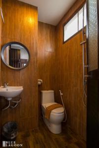 清莱Blue Lagoon Hotel的一间带卫生间、水槽和镜子的浴室