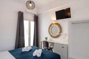 帕罗奇亚Galinos Hotel for adults only的一间卧室配有一张床、一张书桌和一面镜子