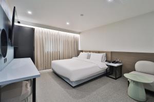 蔚山DOAN STAY HOTEL的酒店客房,配有白色的床和椅子