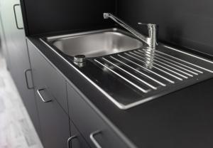 AussersiggamSimotel的黑色台面上的一个不锈钢厨房水槽
