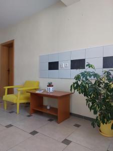 佩斯塔尼PS Apartments - Peshtani的一间设有黄色椅子和书桌的等候室