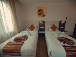 加德满都Hotel Krishna Kathmandu的两张床铺,位于酒店房间,上面有弓形纽带