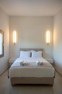 帕尔加Merelia Exclusive Villas的一间卧室配有一张大床和两条毛巾